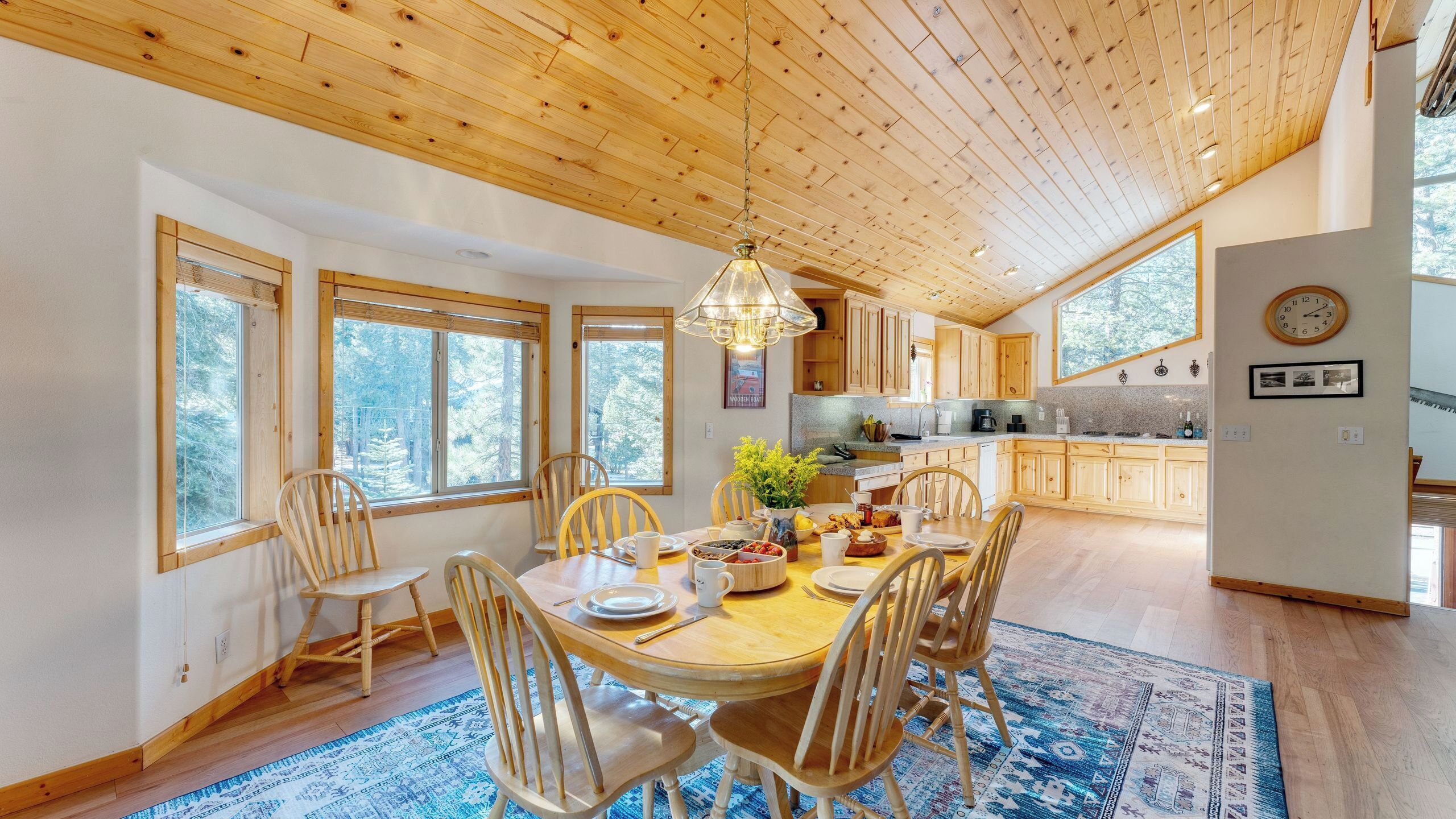 A spacious dining area with a wooden table, chairs, and a chandelier.