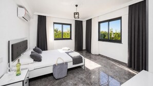 Ein modernes Schlafzimmer mit Bett, Nachttisch, Fenster und Deckenleuchte.