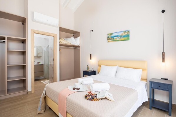 A hotel room with a bed, bedside tables, a wardrobe, and a painting on the wall.