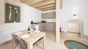 Une cuisine moderne avec des meubles en bois, une table à manger pour quatre personnes et un petit espace piscine.