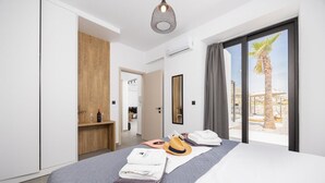 Een moderne hotelkamer met een groot bed, een houten garderobe, een spiegel en uitzicht op palmbomen.