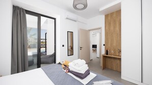 Una habitación de hotel moderna con una cama, un aparador de madera, un espejo y vistas al exterior.