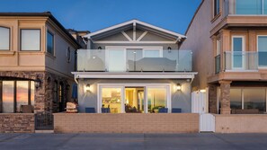 A two-story residential building with a balcony, large windows, and a brick facade. - Balboa Breeze by Avantstay Beachfront Retreat + Ocean View (Newport Beach)