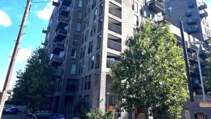 A multi-story building with a modern architectural design, featuring balconies and a brick facade. - London Apartment Oasis - Close to City Center (London)