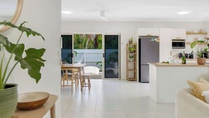 Une cuisine moderne équipée d’un réfrigérateur, d’un four à micro-ondes et d’un coin repas avec des chaises et une table.