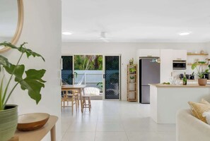 Eine moderne Küche mit Kühlschrank, Mikrowelle und Essbereich mit Stühlen und Tisch.
