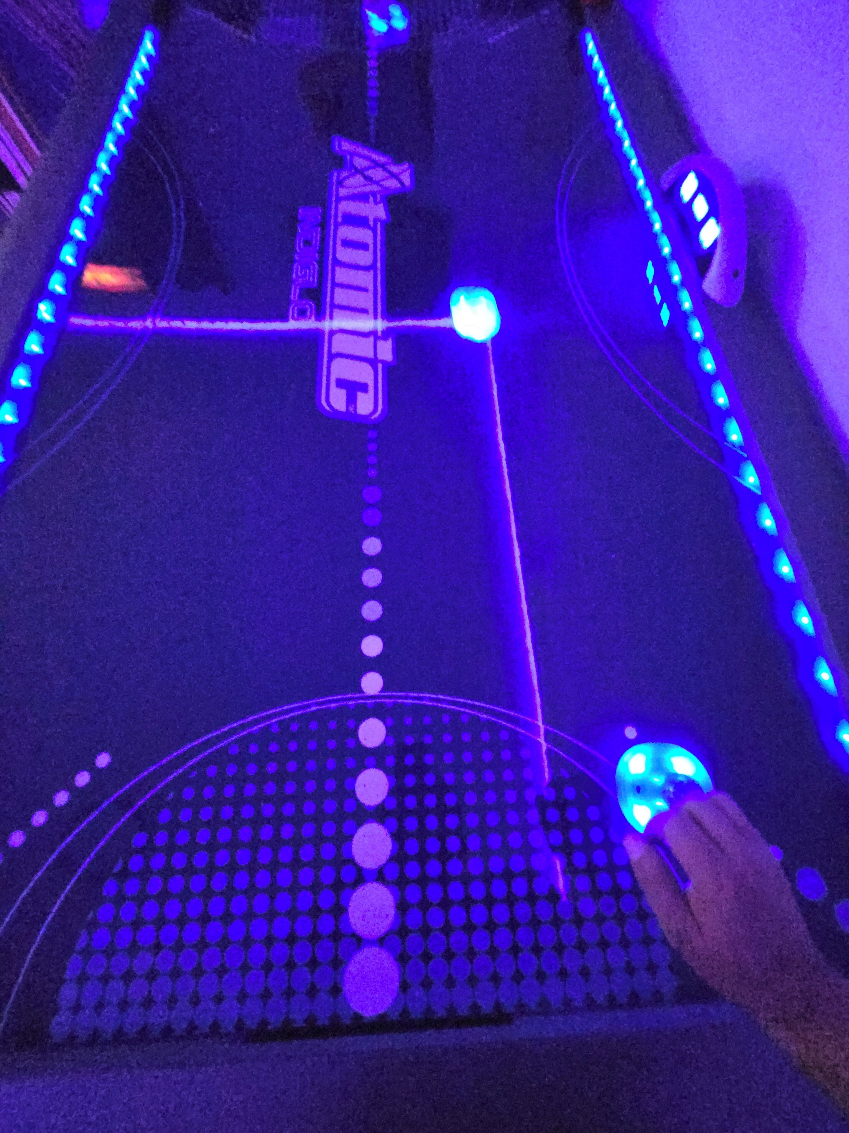 A table with a grid pattern and a hand holding a device with a blue light.