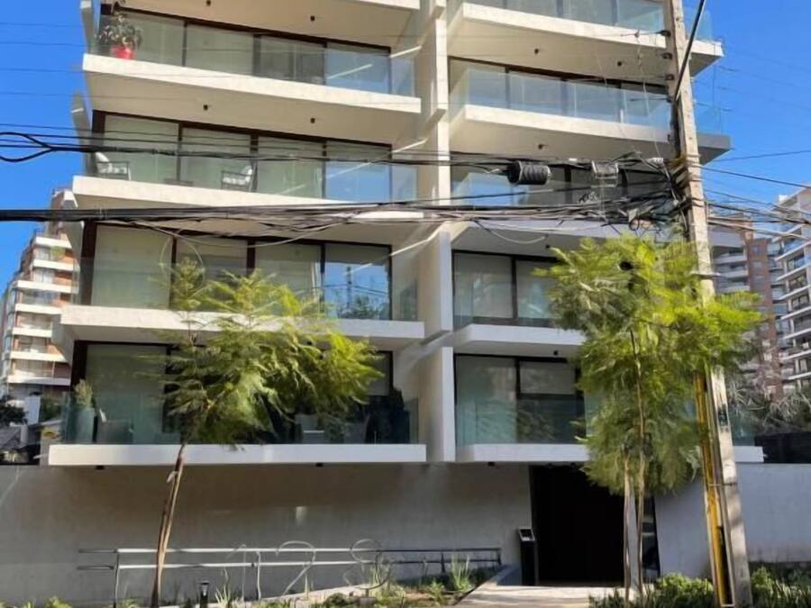 A multi-story building with balconies and large windows.