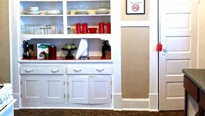 A kitchen with white cabinets, a stove, and a countertop with various items. - 3-bedroom house in wonderful Columbus with AC, WiFi. Enjoy your stay (Columbus)