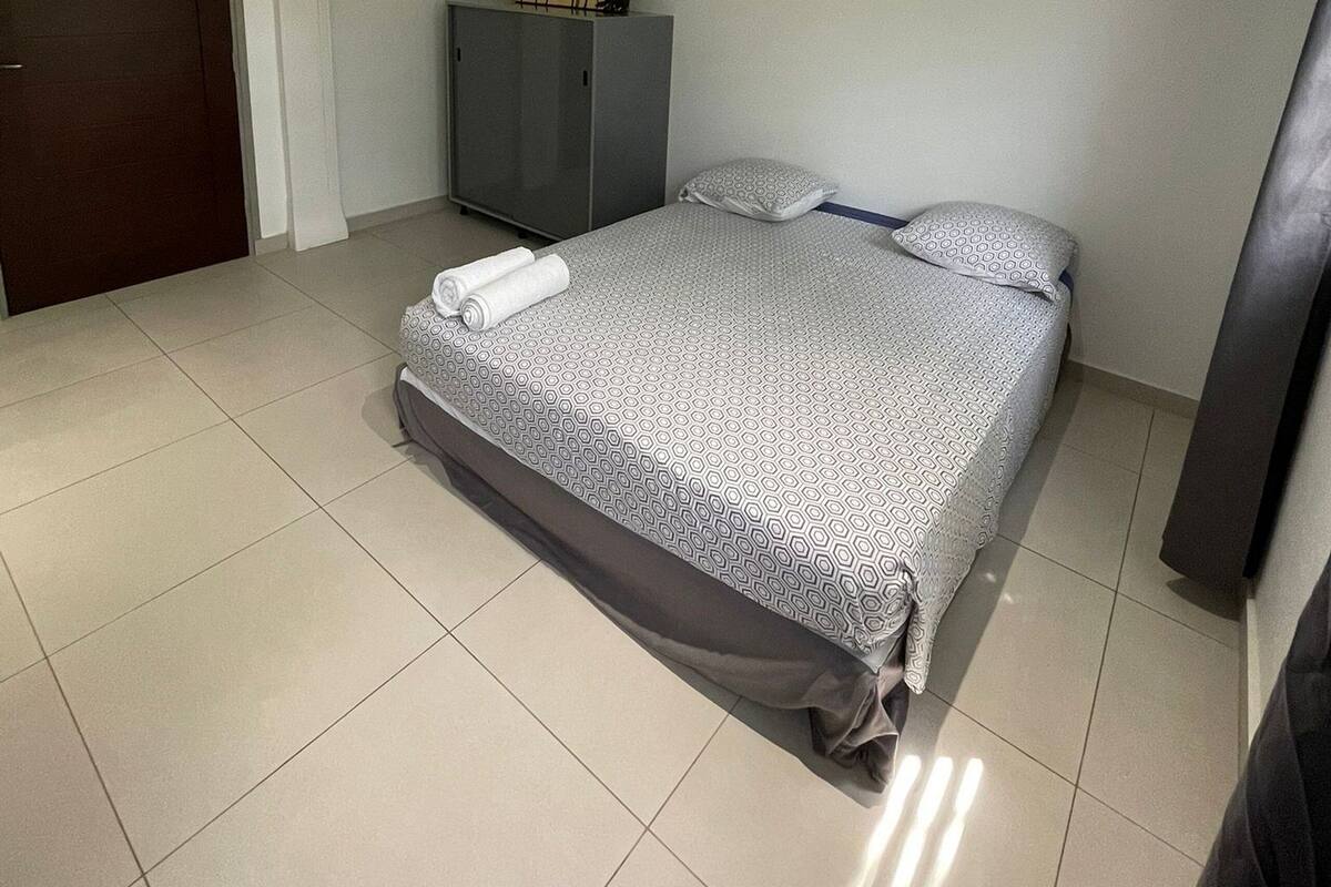 A bedroom with a bed, a wardrobe, and a door.