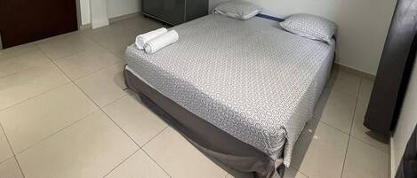 Una camera da letto con un letto, un armadio e una porta.