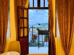 Una stanza con vista sulla città attraverso una finestra con tende.