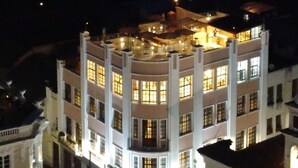 Un edificio de varios pisos con un patio central, que cuenta con balcones y ventanas amplias.