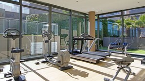 Et fitnessrum med løbebånd, styrkemaskiner og håndvægte.