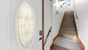 A staircase with wooden steps and a glass door with a decorative pattern. - Oxnard Beach Retreat  (Oxnard)