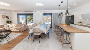 A modern apartment with a dining area, kitchen, and living room.