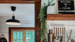Une cuisine avec un plafond en bois, une fenêtre, un évier et une pancarte sur laquelle on peut lire : « BIENVENUE AU CHALET ».