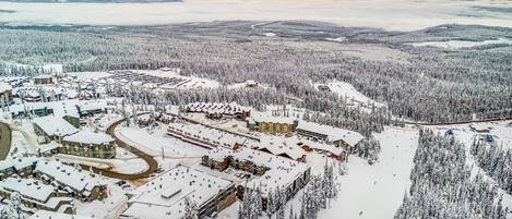 A snow-covered resort with multiple buildings, including lodges and a ski resort.