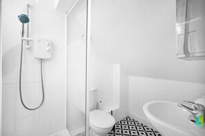 A bathroom with a shower, toilet, and sink.