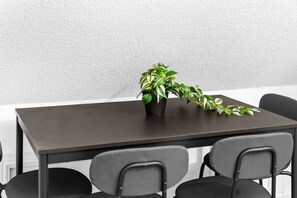 A dark wooden table with a potted plant on it.