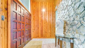 Un pasillo de madera con una pared de piedra y un busto blanco.
