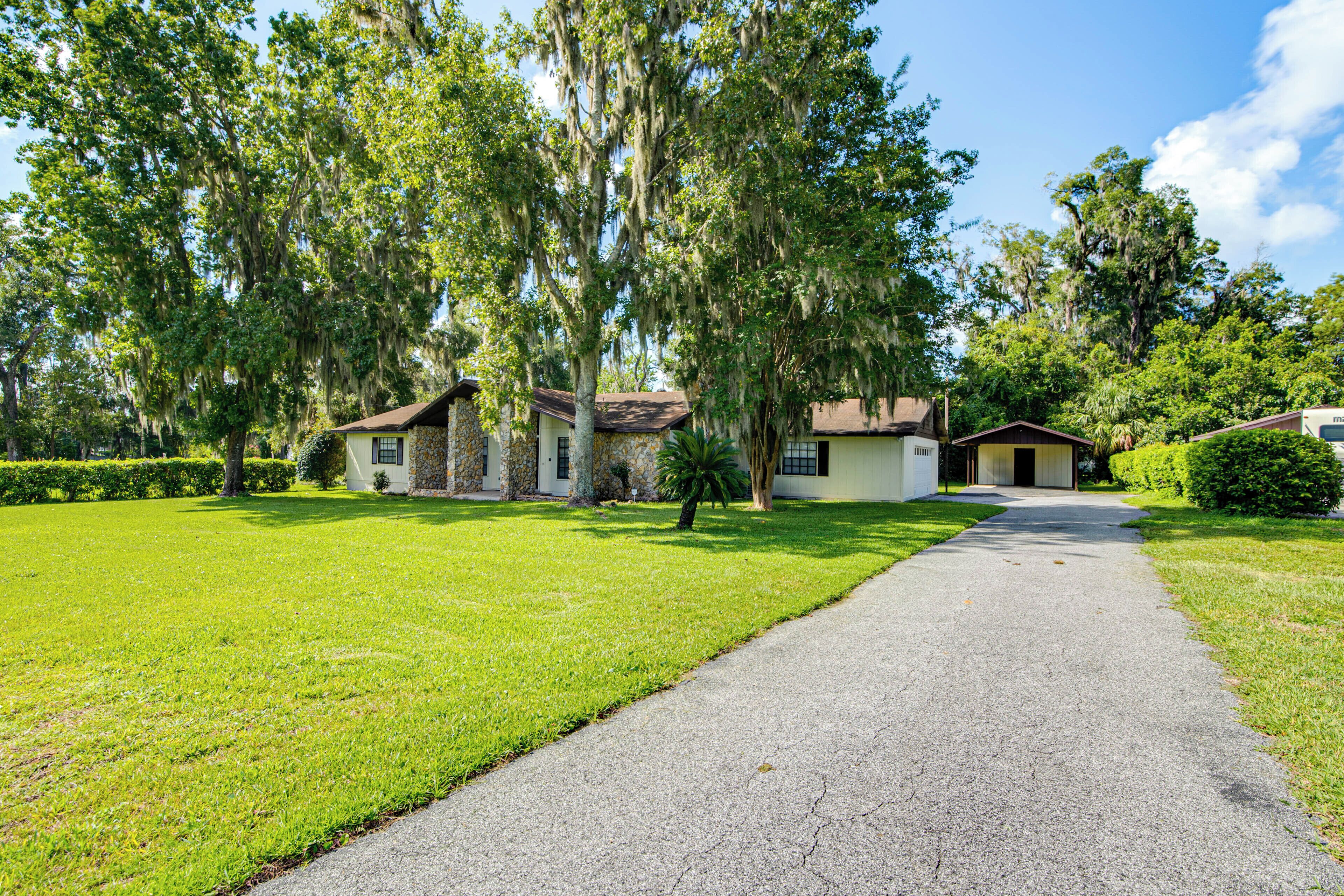 A residential area with a paved driveway leading to a row of houses.