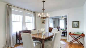 A dining room with a wooden table, four chairs, a chandelier, and a view of the adjacent living area. - 4 Mi to Dtwn: Baton Rouge Bungalow w/ Private Yard (Baton Rouge)