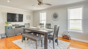 A dining area with a wooden table, chairs, and a bench. There is a ceiling fan, a clock on the wall, and a window with blinds. - 1 Mi to Dtwn: Home w/ Furnished Patio in Pensacola (Pensacola)