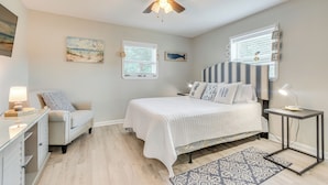 A bedroom with a bed, bedside tables, a desk, a chair, a ceiling fan, and artwork on the walls. - 1 Mi to Dtwn: Home w/ Furnished Patio in Pensacola (Pensacola)