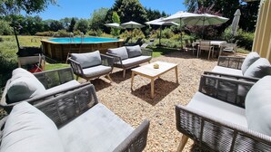 An outdoor patio with wicker furniture, a pool, and umbrellas. - Gîte le Quai (8 people) (Champagnac-la-Rivière)