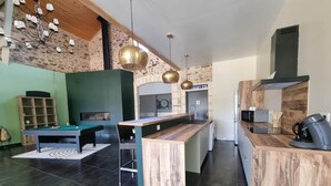 A modern kitchen with a wooden island, a pool table, and a bar area. - Gîte le Quai (8 people) (Champagnac-la-Rivière)