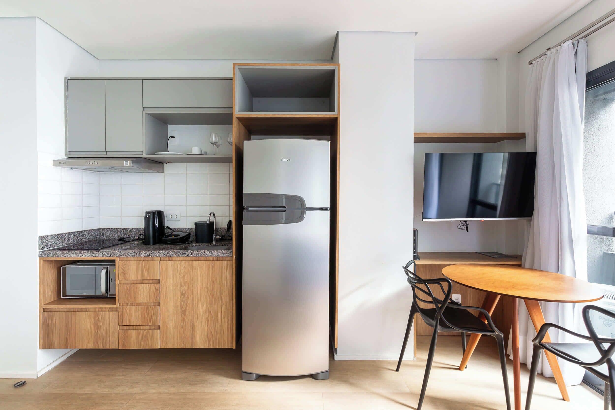 A compact kitchenette with a built-in refrigerator, a microwave, and a coffee maker.