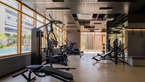 Ett gym med olika träningsmaskiner, stora fönster och utsikt över omgivningen.