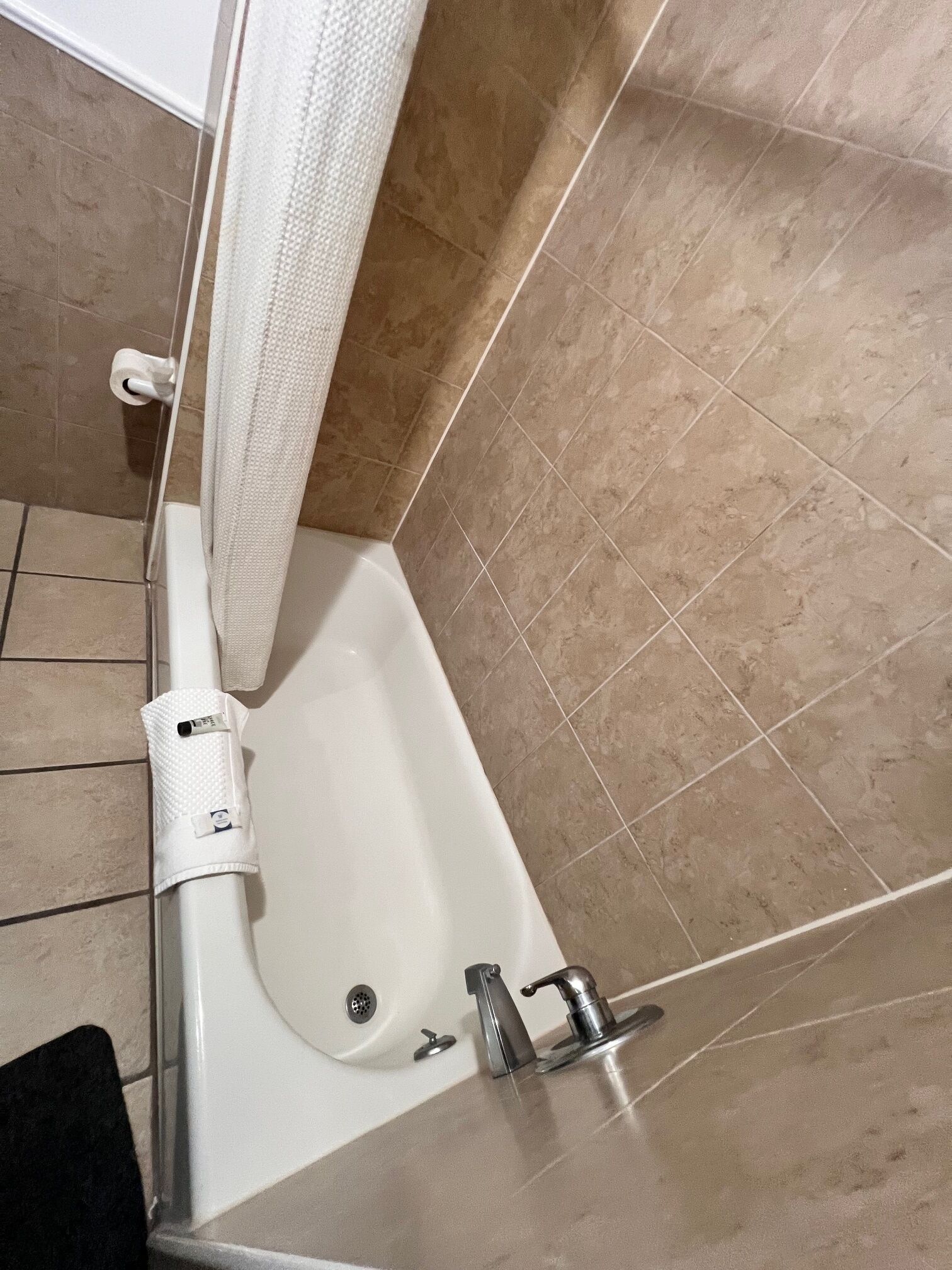 Un bagno con una vasca, una tenda da doccia e un lavandino.