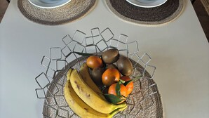 A dining table set with plates, bowls, a glass pitcher, and a fruit bowl. - Charming and spacious Breton house (Jugon-les-Lacs)