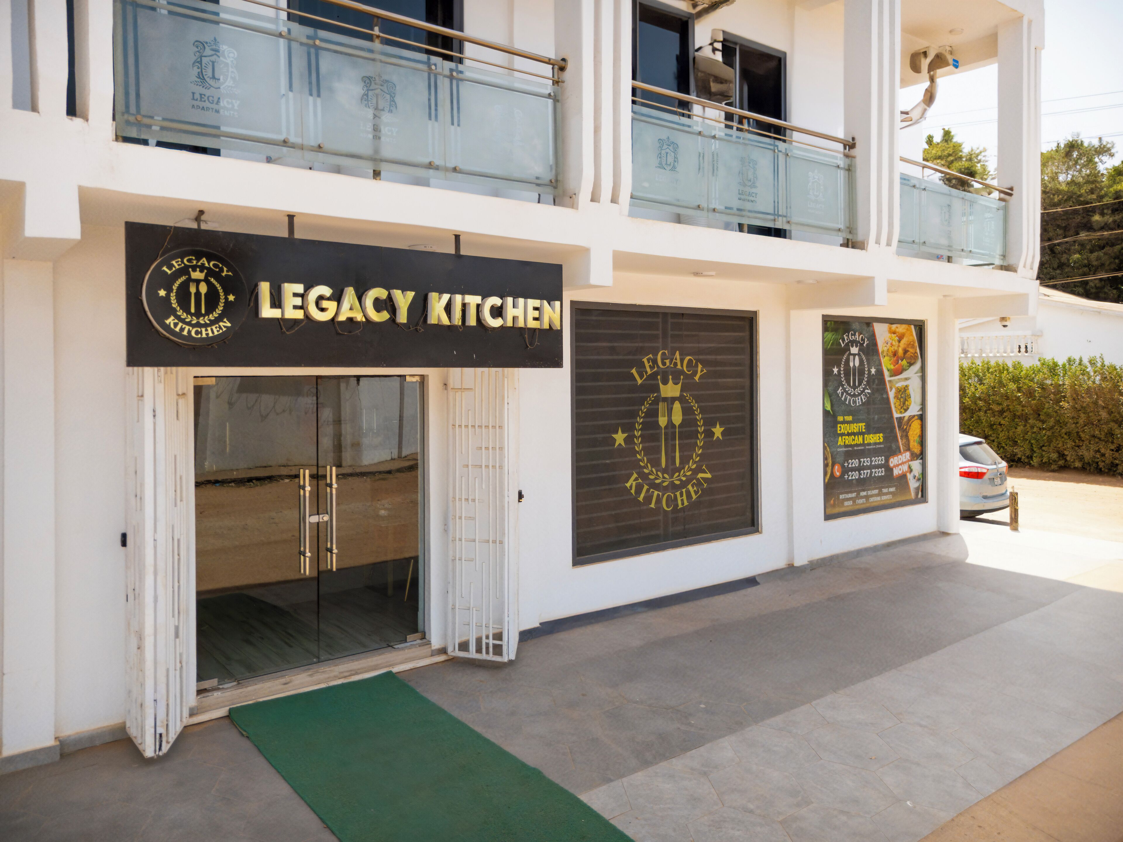Un edificio con un letrero que dice "Legacy Kitchen" y un coche estacionado afuera.