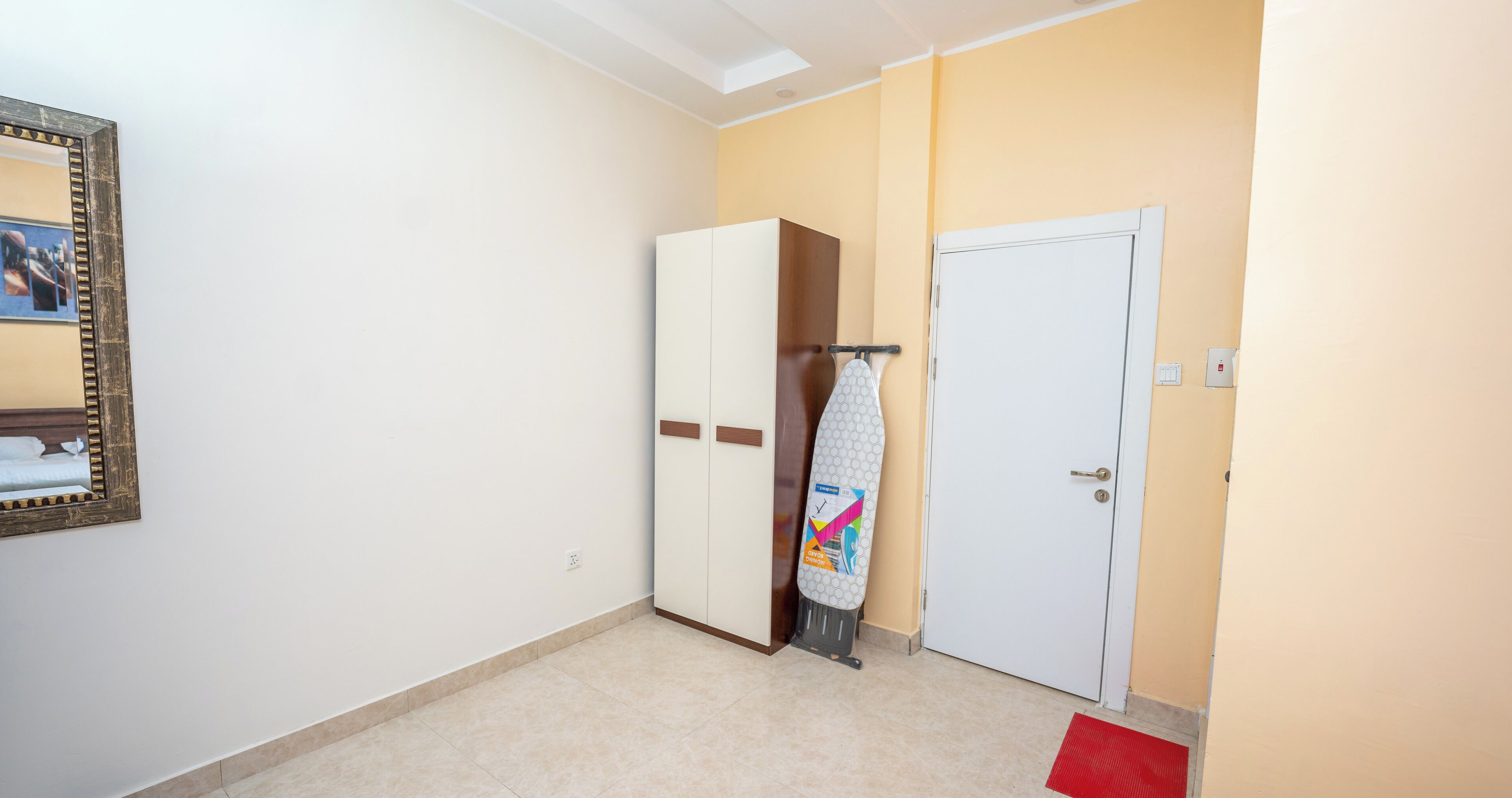 Une pièce avec une armoire, une porte et un miroir.