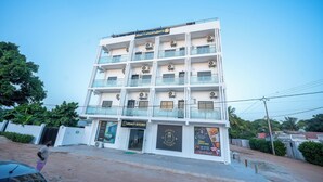 A multi-story building with balconies, air conditioning units, and a sign for 'Legacy Apartments'. - Legacy Apartments Phase 4 (Serrekunda)