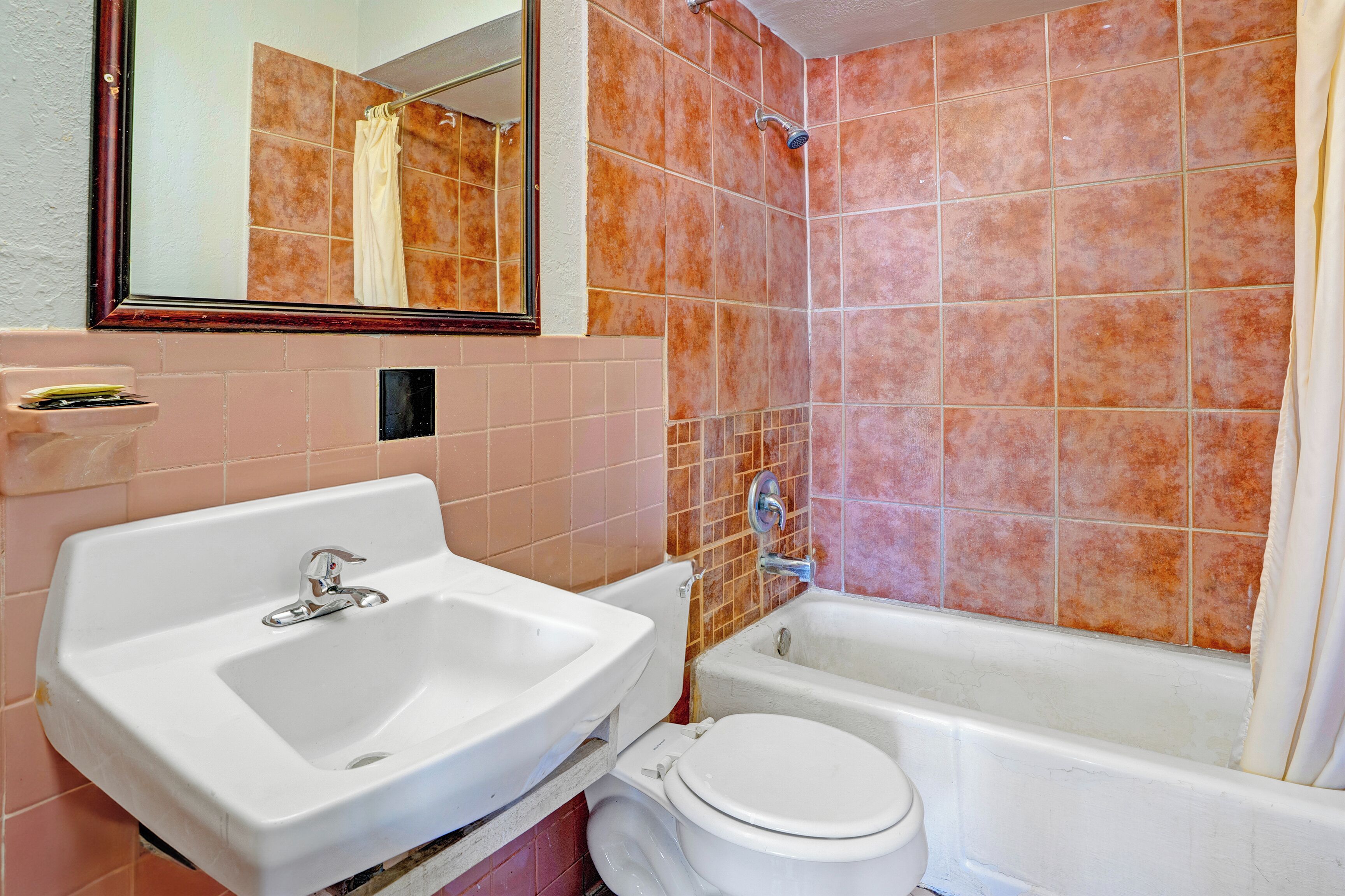 A bathroom with a sink, toilet, and bathtub.