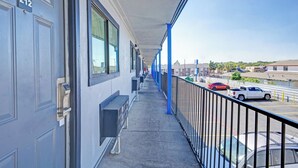 A balcony with a view of parked cars and buildings in the distance. - Super 7 Inn By Oyo San Antonio N.W. Medical Center (San Antonio)