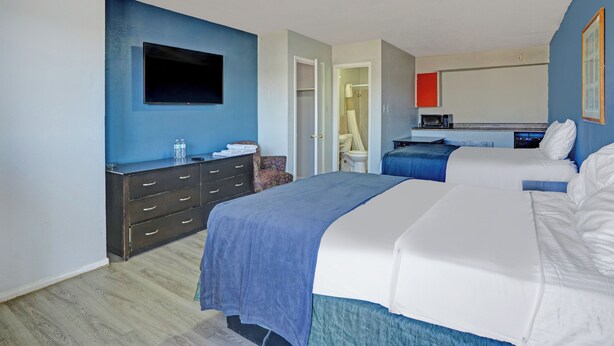 A hotel room with two beds, a flat-screen TV, a dresser, and a microwave. - Super 7 Inn By Oyo San Antonio N.W. Medical Center (San Antonio)