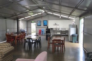 Un espacio interior amplio con una mesa de comedor, sillas, un sofá y una cocina equipada.