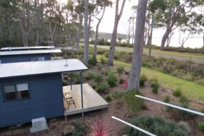 A small, single-story building with a flat roof, surrounded by a landscaped garden with various shrubs and a paved area. - Bruny Island Holiday Park Adventure Bay (Adventure Bay)