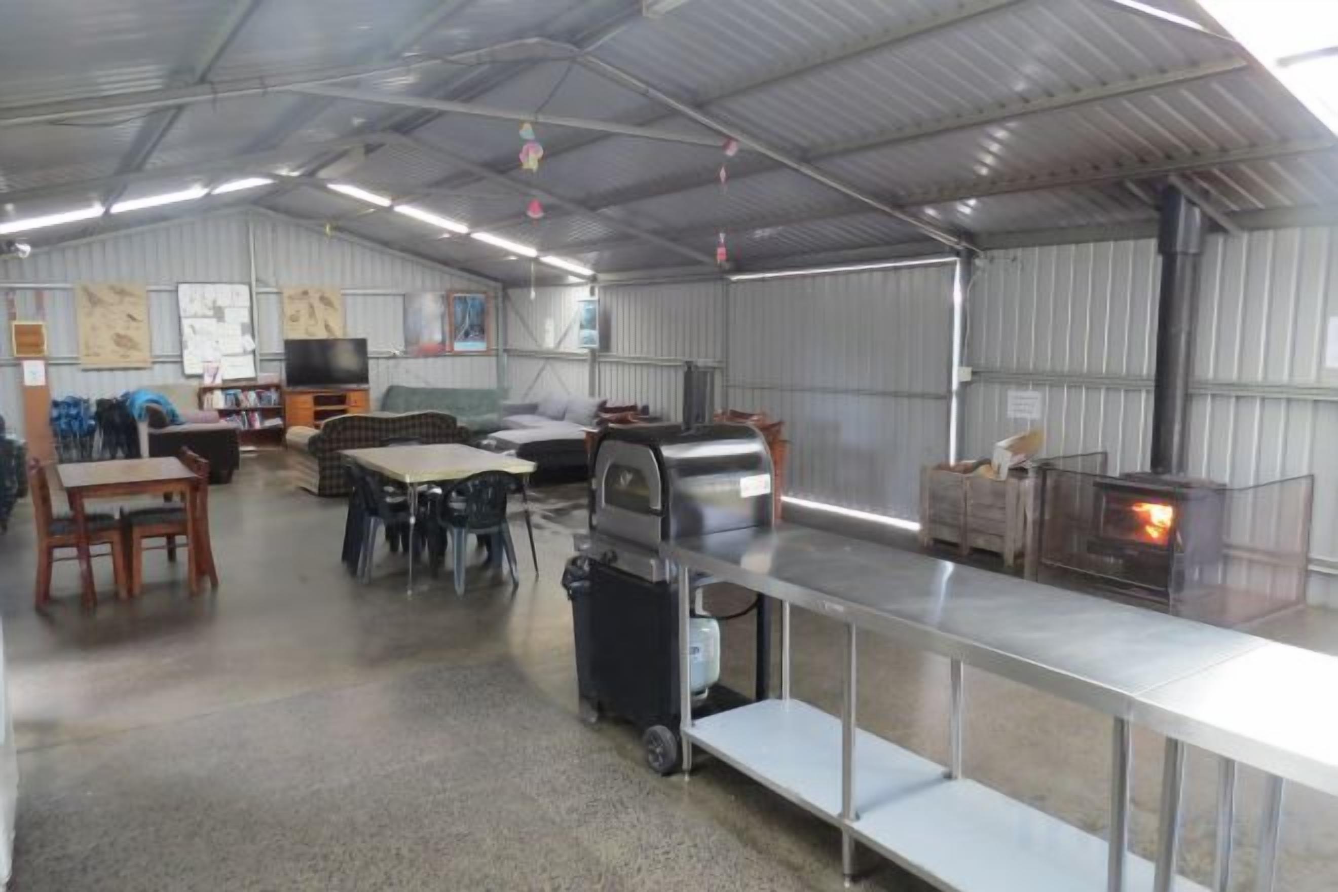 A spacious indoor area with a long counter, a grill, and a television.