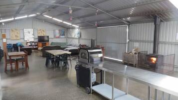 A spacious indoor area with a long counter, a grill, and a television.