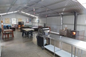 Un espacio interior amplio con una barra larga, una parrilla y un televisor.