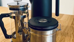 A stainless steel French press and a Gator insulated mug on a wooden table. - 1.5-room apartment with terrace (Pirna)