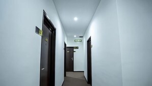 A narrow, well-lit hallway with doors on both sides, leading to a room marked 'OBBA'. - Grand Bagan Hotel (Butterworth)