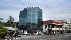 A modern hotel with a glass facade, named "Grand Bawan Hotel," and a ground-level commercial area with various shops. - Grand Bagan Hotel (Butterworth)