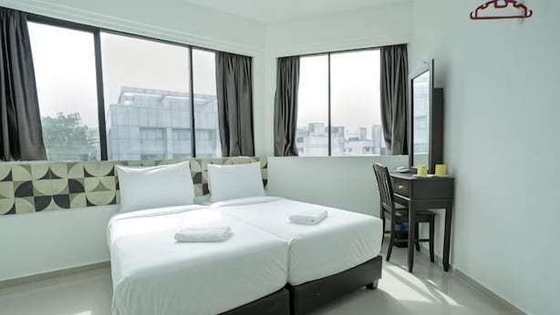 A hotel room with a large bed, a desk, and a view of the city. - Grand Bagan Hotel (Butterworth)